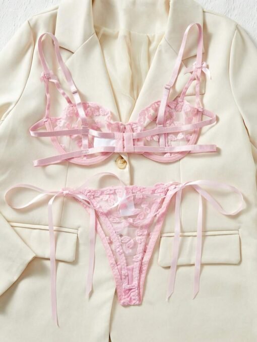 Conjunto sexy rosa con transparencias, detalle de tanga sobre fondo claro.