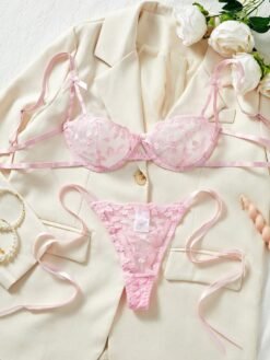Conjunto sexy rosa con encaje bordado sobre saco beige, vista frontal.