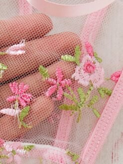 Detalle de copa con flores bordadas en el set de lencería rosa