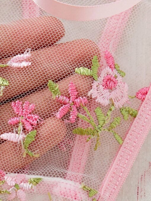 Detalle de copa con flores bordadas en el set de lencería rosa