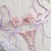 Vista frontal del set de lencería morado con bordado floral y lazos.