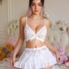 Modelo luciendo conjunto sexy blanco con encaje y mini falda