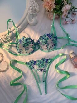 Set de lencería verde con bordado floral y sujetador balconette sobre fondo satinado.