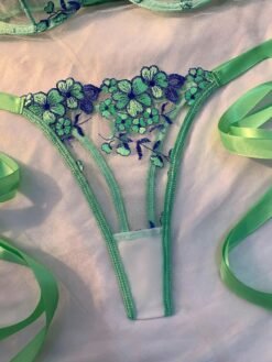 Primer plano de la tanga verde bordada con diseño floral transparente.
