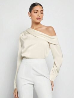 Top albaricoque elegante combinado con pantalón blanco.