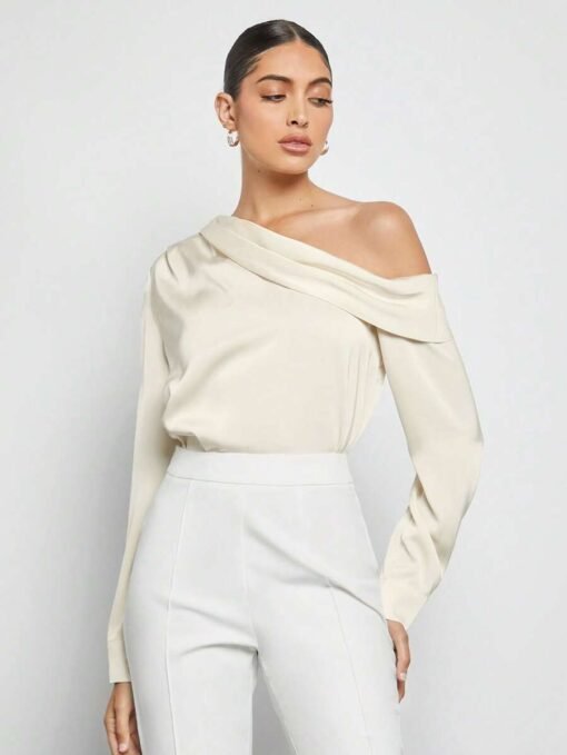 Top albaricoque elegante combinado con pantalón blanco.