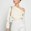 Modelo usando top albaricoque elegante con caída fluida