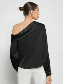 Vista trasera del top negro elegante con escote diagonal.