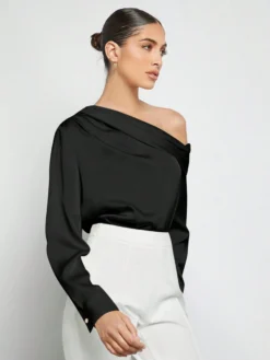 Top negro elegante combinado con pantalón blanco.