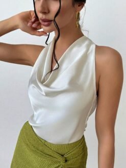Detalle del escote drapeado en top albaricoque elegante.
