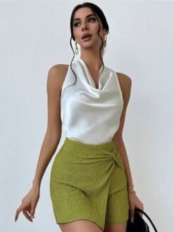 Modelo usando top albaricoque elegante con shorts verdes texturizados.