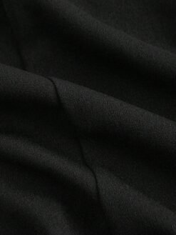 Textura de la tela tricotada del vestido mini negro