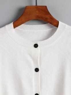 Cuello redondo del cardigan blanco básico con textura suave.