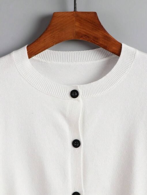 Cuello redondo del cardigan blanco básico con textura suave.