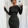 Mujer usando vestido elegante negro con cuello asimétrico de frente