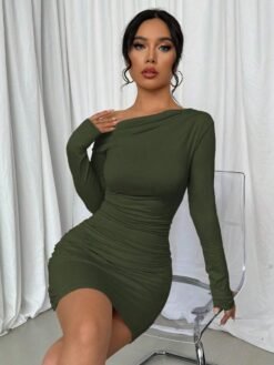 Mujer sentada luciendo el vestido elegante verde con escote asimétrico