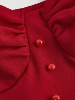 Detalle del fruncido del pecho en el vestido corto rojo.