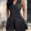 Conjunto blazer negro sin mangas con botones visto de frente.