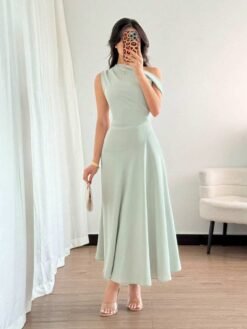 Vestido verde elegante con escote asimétrico visto de perfil