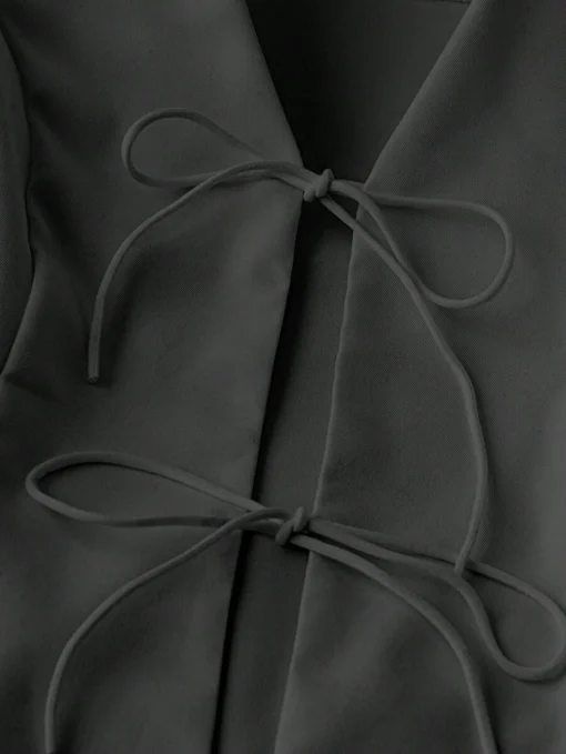 Detalle del escote y los nudos decorativos del conjunto negro casual
