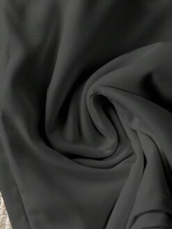 Vista cercana de la tela del conjunto negro casual mostrando textura suave