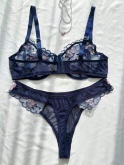 Vista trasera del set de lencería azul con transparencias y bordados.