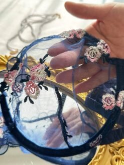 Primer plano de la copa transparente con bordados del set de lencería azul.