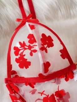 Detalle de los tirantes finos y bordado floral del conjunto sexy rojo.