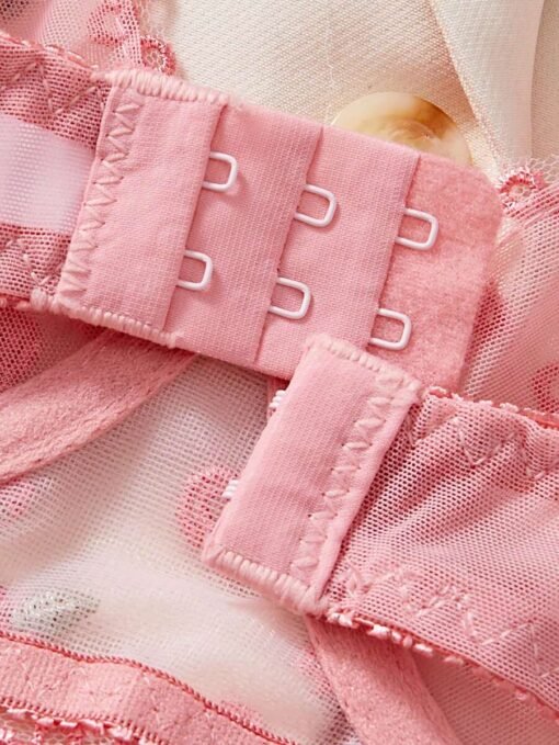 Detalle de tirantes y cierre del set de lencería rosa bordado floral.