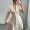 Vestido corto elegante albaricoque con botones y cuello vuelto cruzado.