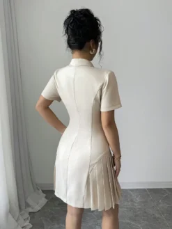 Vista trasera del vestido corto elegante albaricoque con plisado.