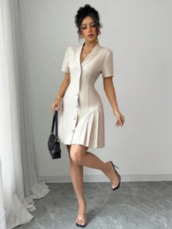Modelo luciendo vestido corto elegante albaricoque con bolso negro.