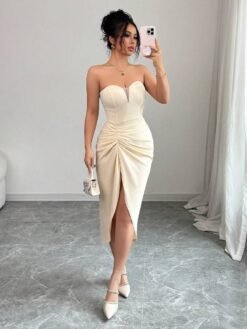Modelo luciendo el vestido elegante sin tirantes color albaricoque con accesorios.