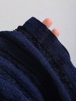 Detalle de la tela tricotada azul marino del vestido mini elegante.