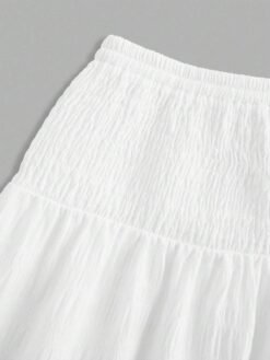 Detalle de la cintura fruncida de la falda larga blanca.