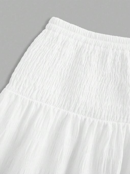 Detalle de la cintura fruncida de la falda larga blanca.