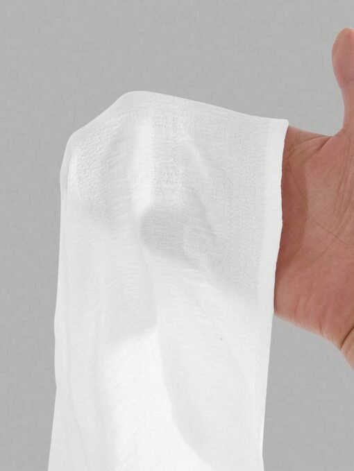 Detalle de la tela y textura de la falda larga blanca.